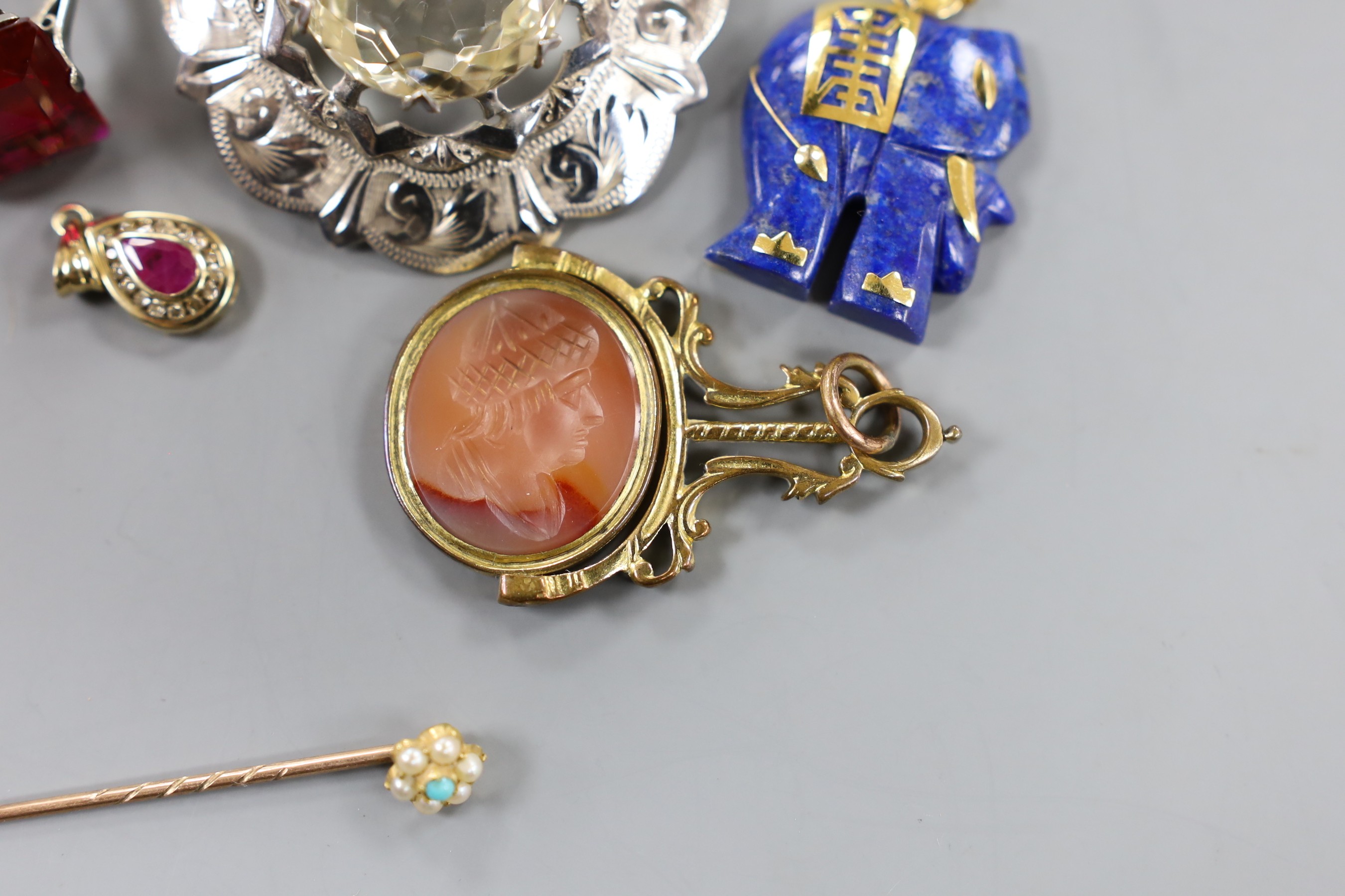 A modern yellow metal, ruby and diamond cluster set pear shaped pendant, overall 20mm, a Scottish silver mounted citrine brooch, a 9k mounted lapis lazuli elephant pendant, a 9ct dress ring, a gilt metal mounted and inta